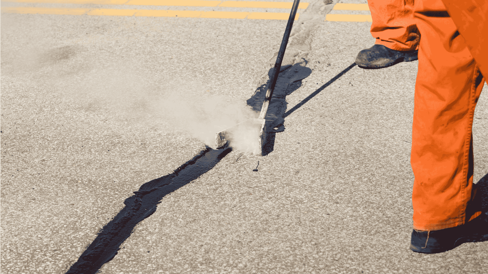 Road crew applying hot sealant to repair asphalt cracks and prevent further pavement damage in Jacksonville, TX.