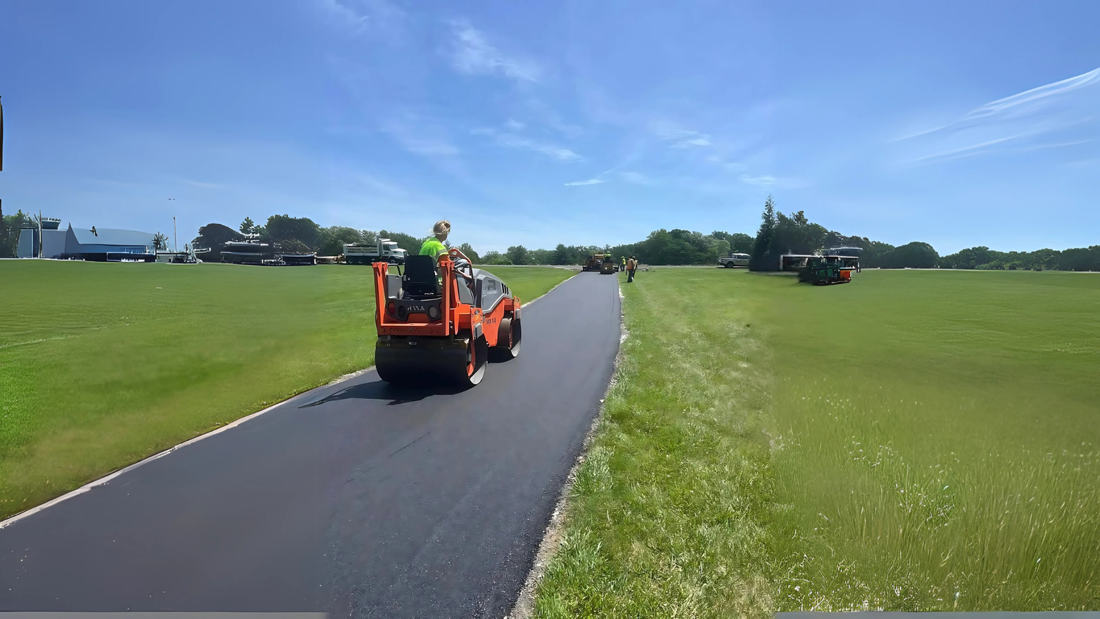 Road roller smoothing freshly paved asphalt driveway for a durable and long-lasting surface in Jacksonville, TX.